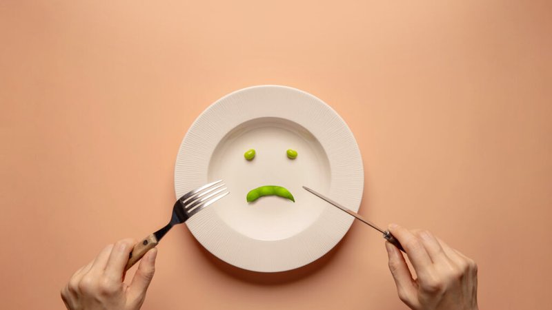 young-woman-using-fork-knife-eating-green-soy-bean-plate-1024x588